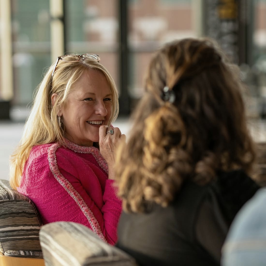 Janet Elliott laughing in conversation with a colleague.
